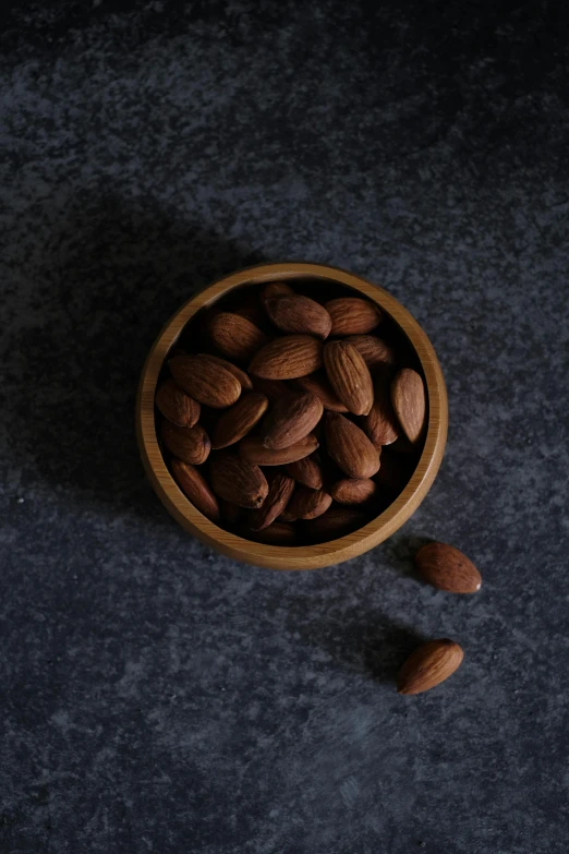 almonds in a bowl and a whole almond beside it