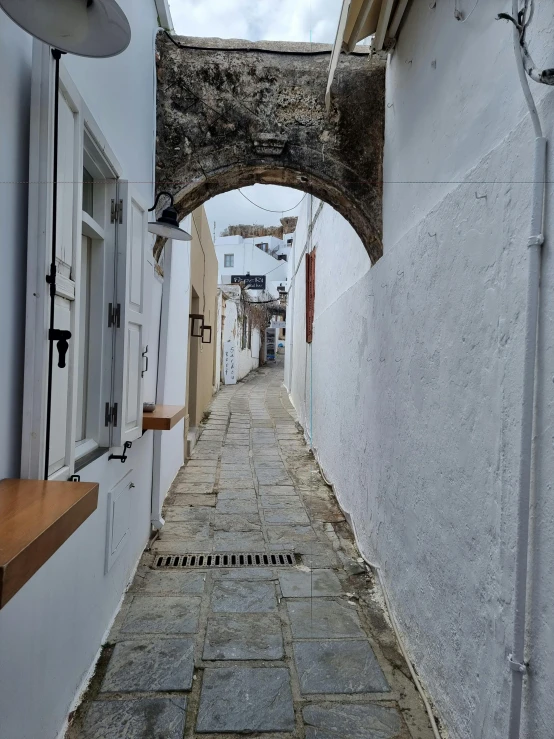 a sidewalk area with an arch leading to the door