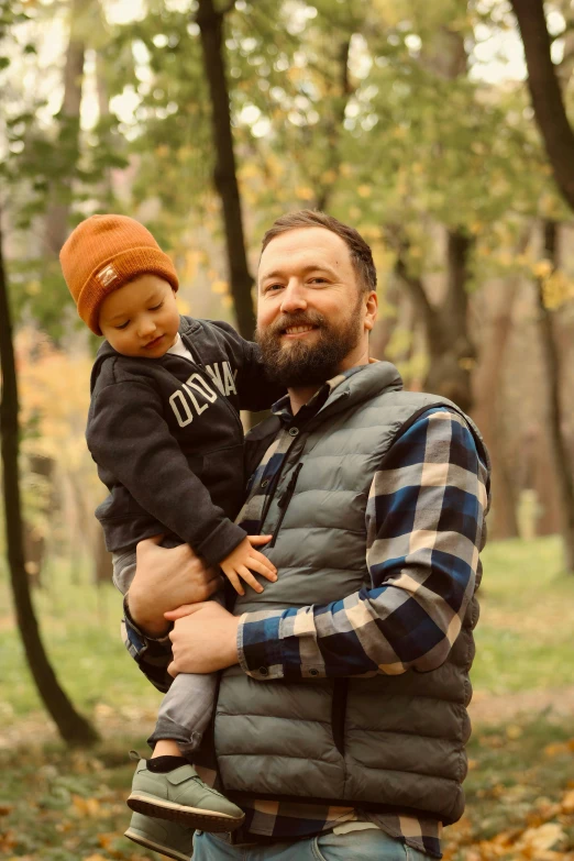 a man holds a little boy as they pose for a po