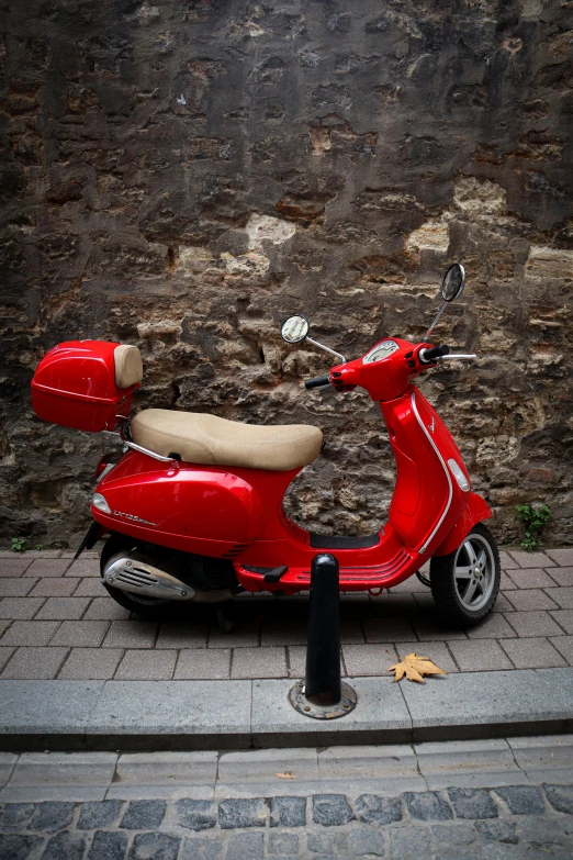 a red motor scooter parked on the sidewalk