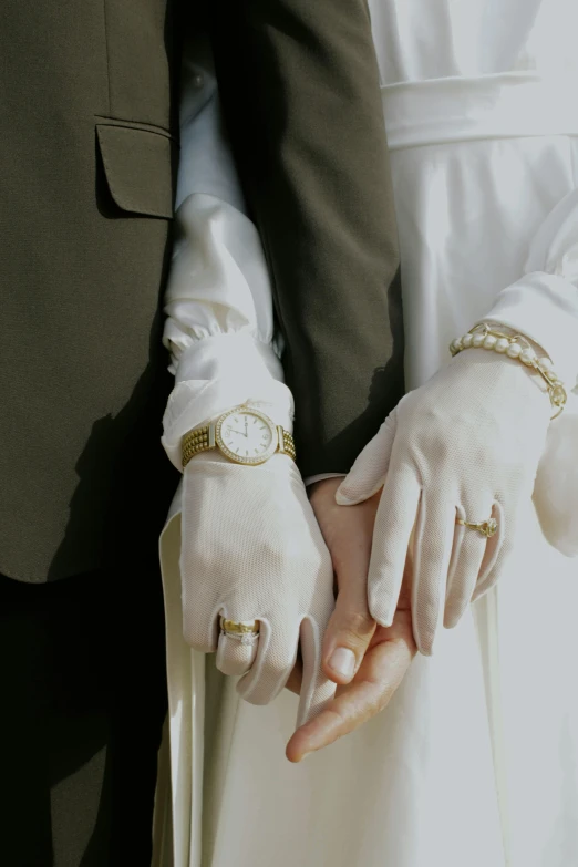 bride and groom hold hands holding hands while dressed in white