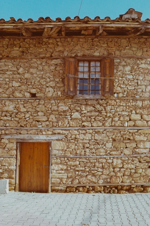 old stone building that is brick with tile and small windows