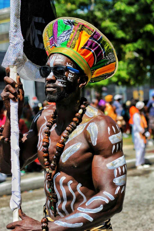 a man is dancing in a festival wearing face paint