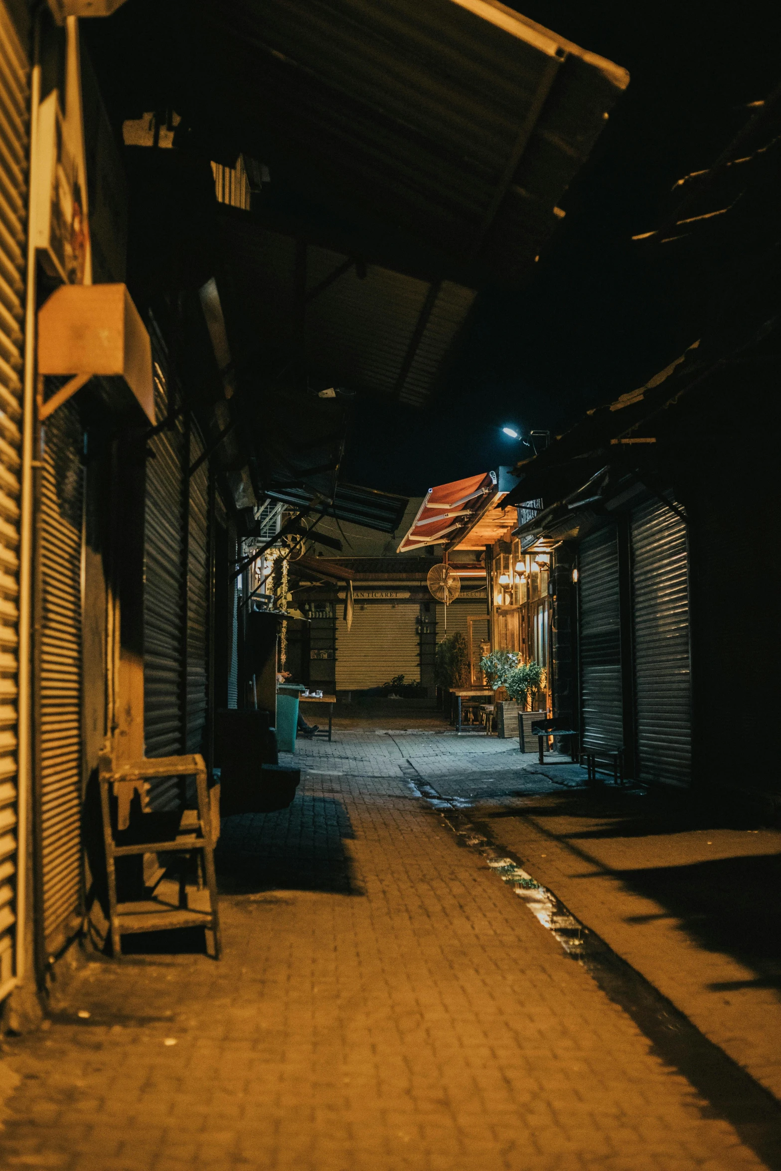 an old alley with lights shining down on a building