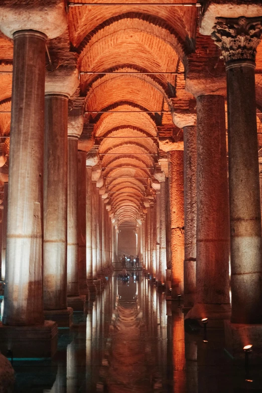 a tunnel of large marble columns is lit by daylight