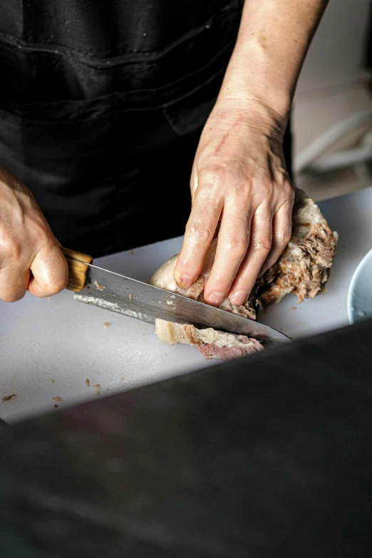 a person chopping meat with a knife