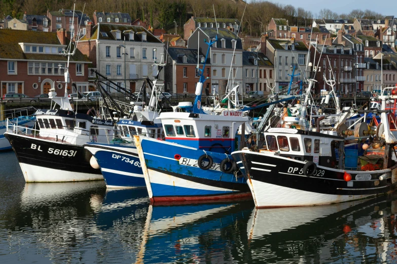 five different color boats sit docked in a marina