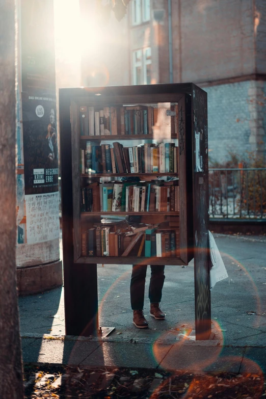 a person under a book shelf on the side of the road