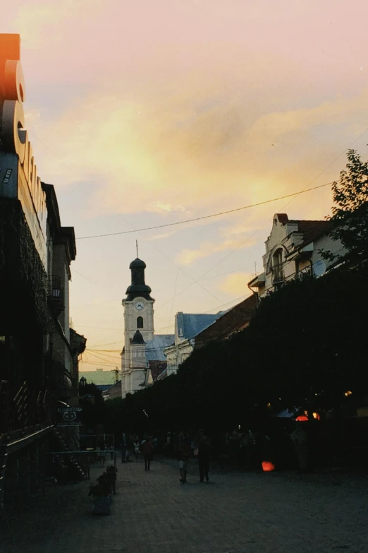 the clock tower is on the side of a building in a small alley