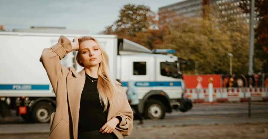 a woman poses by her truck in the city