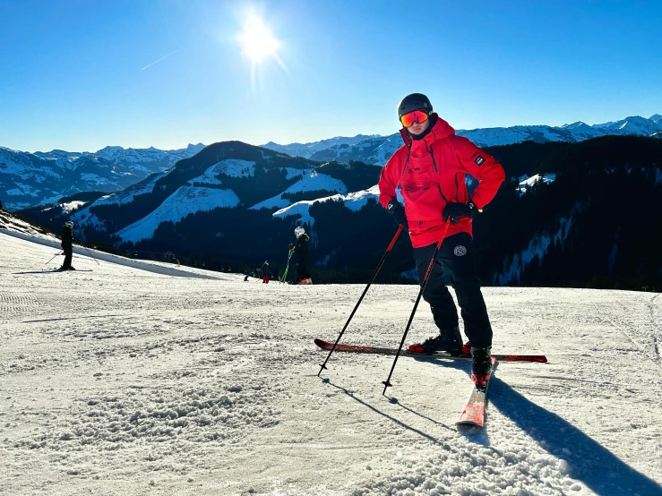 a man standing on a ski slope while wearing skis