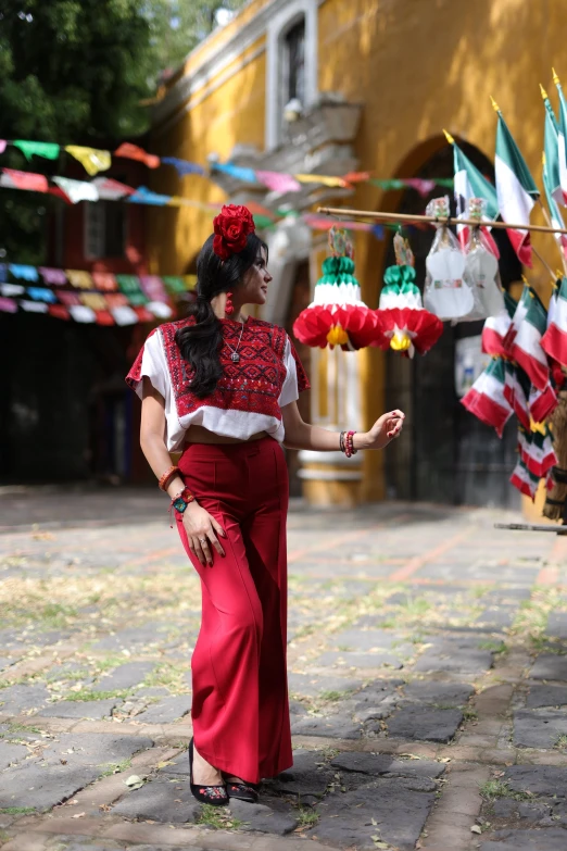 a woman in a spanish outfit holds up paper lanterns