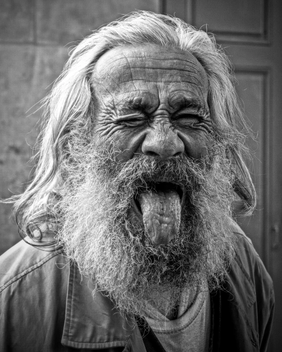 a bearded man with a huge smile and his tongue hanging out