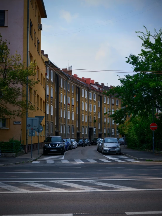 traffic on a city street with cars parked along side of the buildings