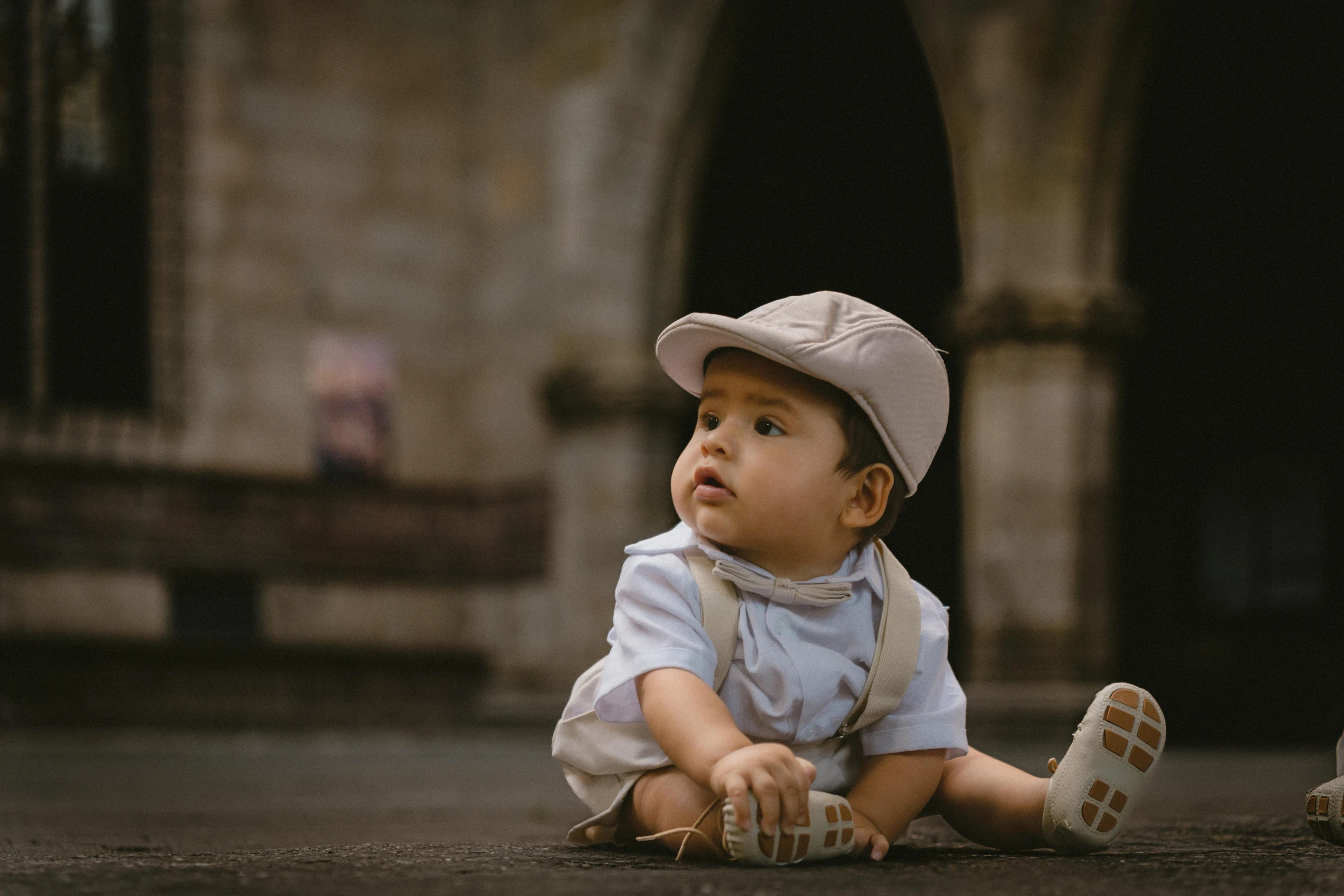 a little baby is sitting down with his legs up