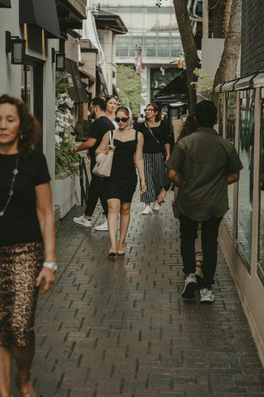 a group of people walking down a road next to a building