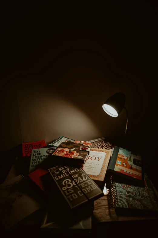 a light shines on a desk filled with books