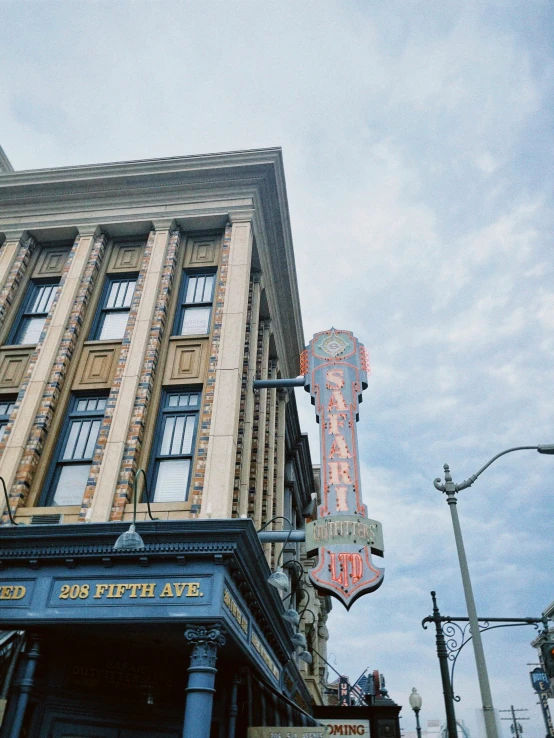 a tall building with a giant neon sign over it