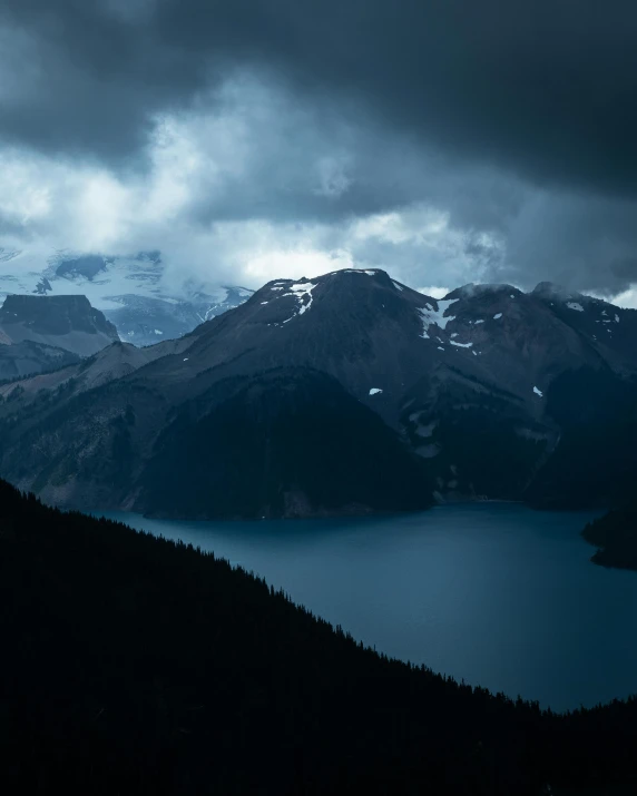 two large mountains that are near some water