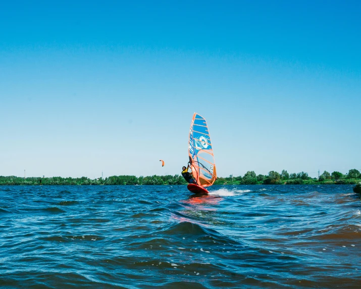 a couple of people in water holding sail boards