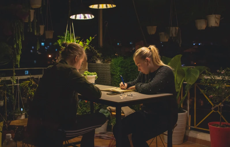 two women are sitting down at a table eating