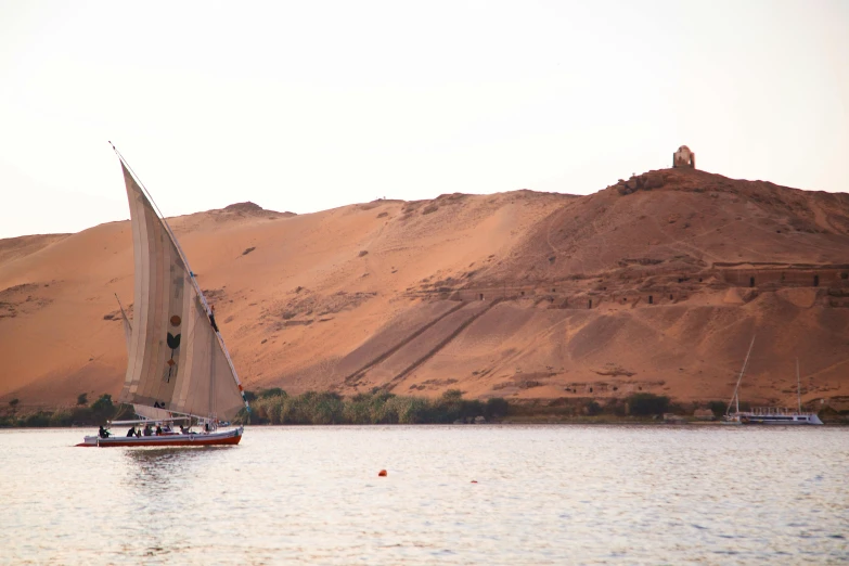 a sail boat floating on top of a body of water