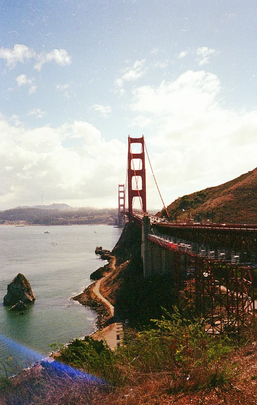 a large suspension bridge over water next to a mountain