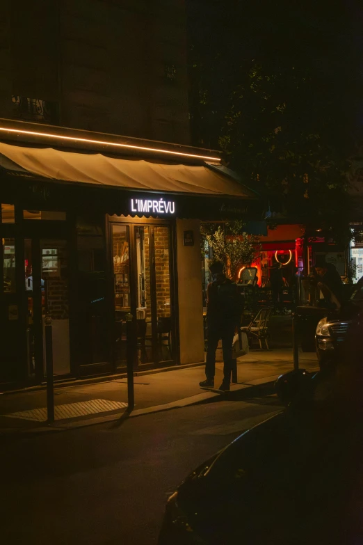 people standing outside of an eatery in the dark