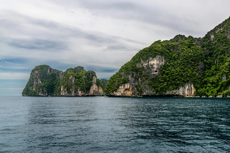 an ocean with boats near the mountains