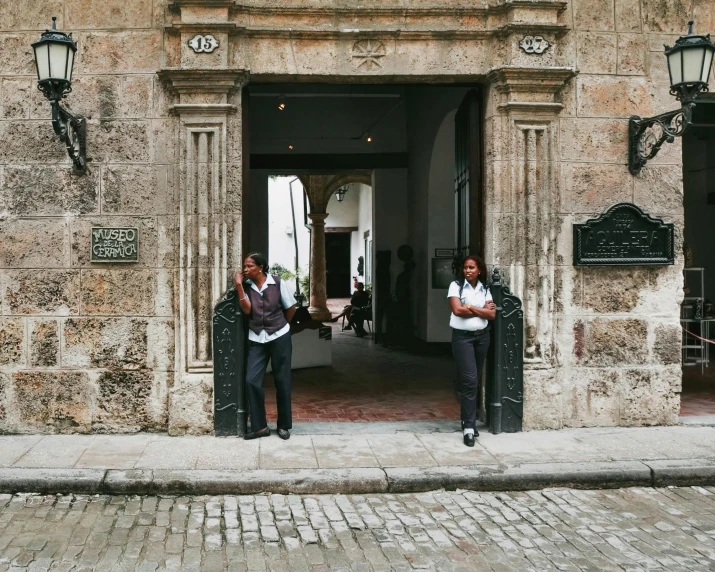 two men stand outside of a building doorway