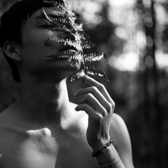 a shirtless man is holding a flower