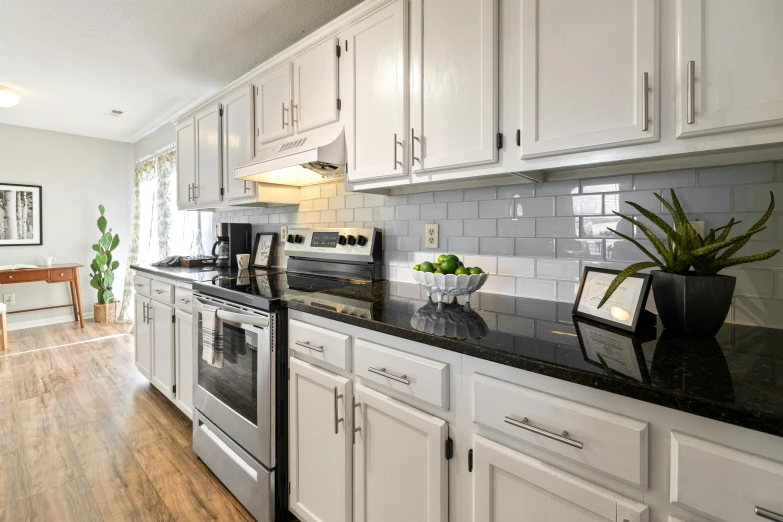 an image of a clean kitchen setting with black counter tops