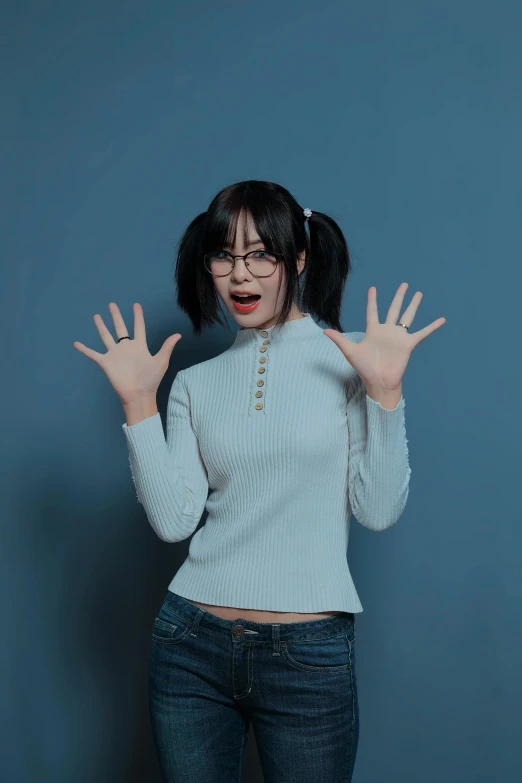 a woman in a sweater is making the hand gesture