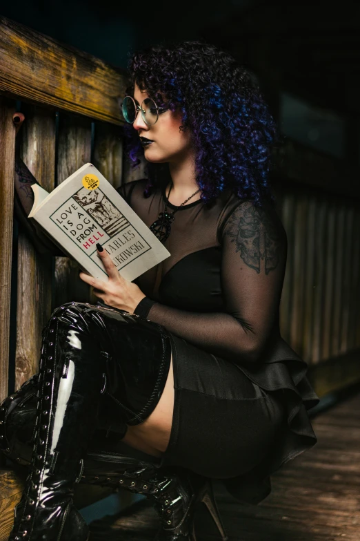 a beautiful woman in tights reading on a fence