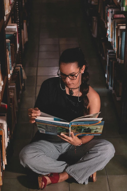 a woman sitting on a bench reading a book