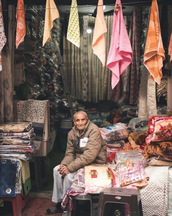 there is a man sitting in front of a colorful display