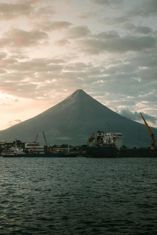 the boats are traveling down the water by the mountain