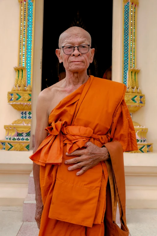 an old man with glasses, in orange clothes