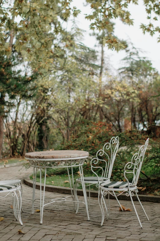 a table and two chairs in the middle of a paved area