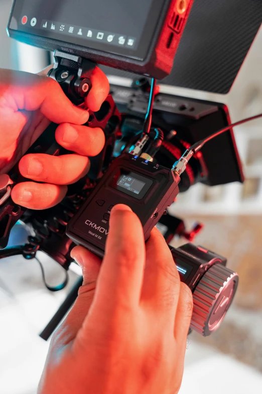 a person holding a video camera up to a screen