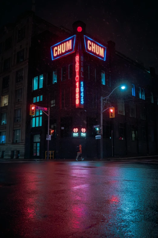 a building is lit up at night on the corner of a city street