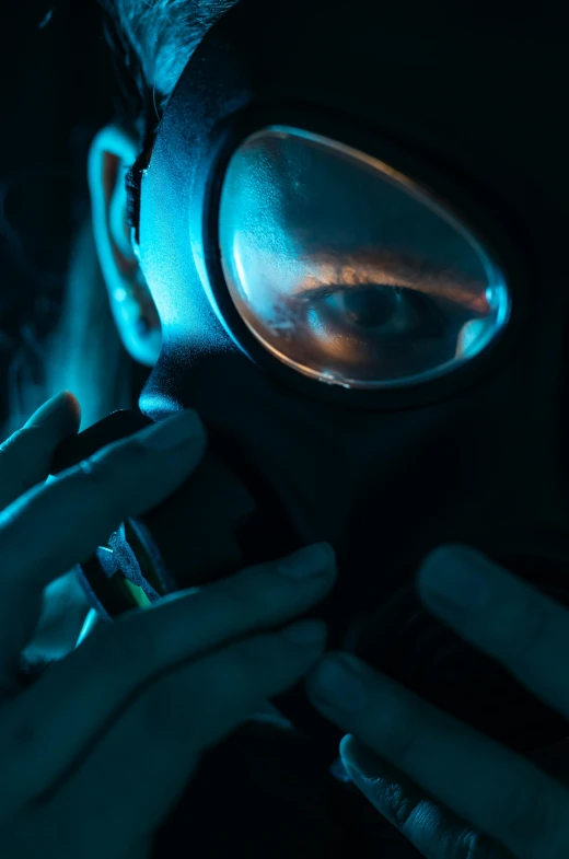 a man in the dark wearing a gas mask