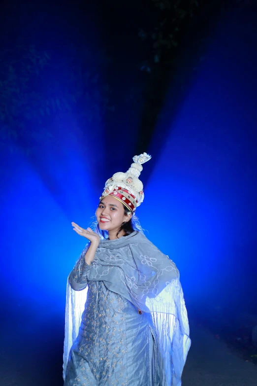 a woman wearing a blue gown posing for a po