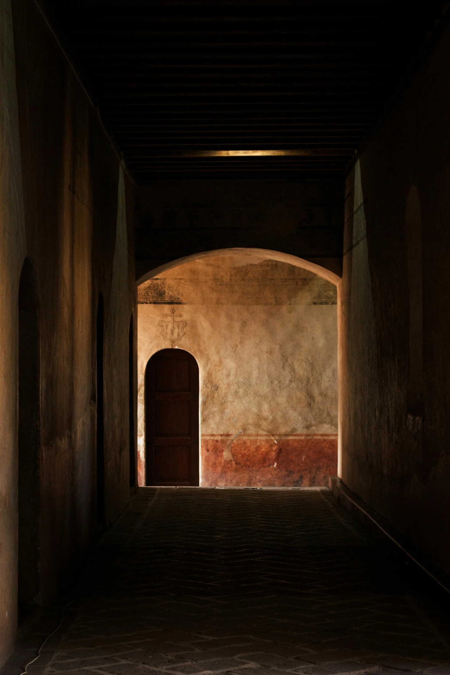 a dimly lit walkway in a very old building