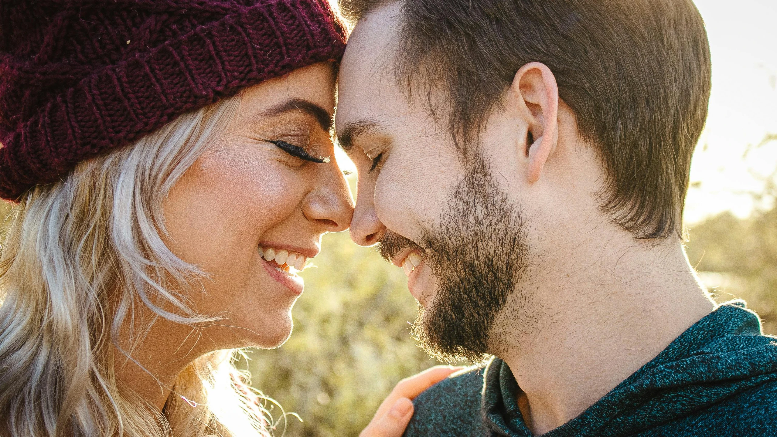 couple kissing in field with fall colors