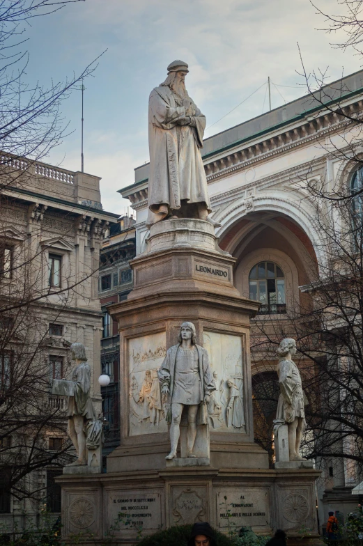 a woman standing by a monument with two statues