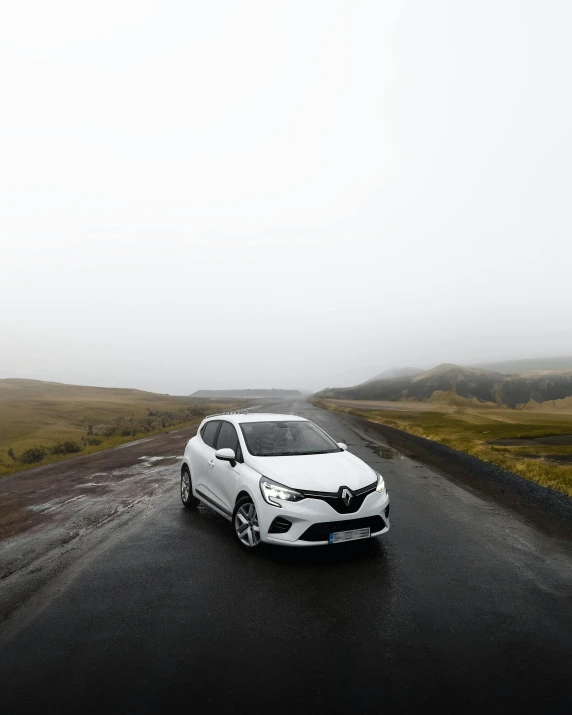 the toyota mira hatchback is driving through the foggy desert