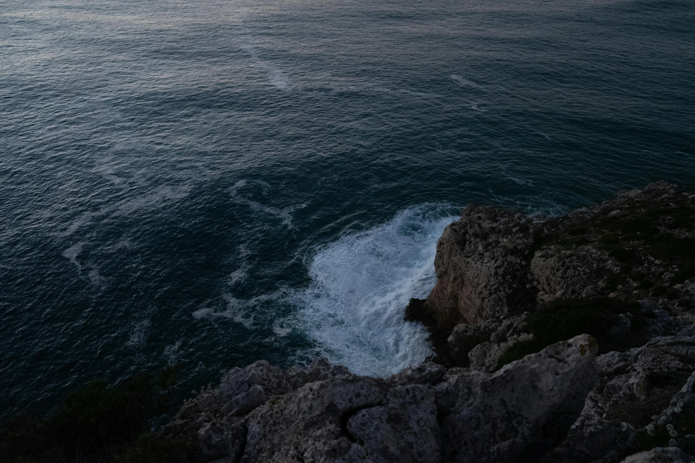 a body of water with a rocky shore