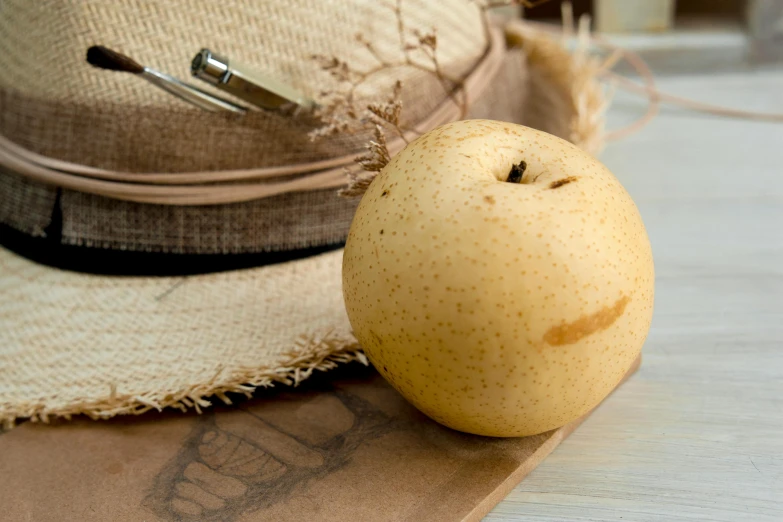 an apple and hat sitting on a table