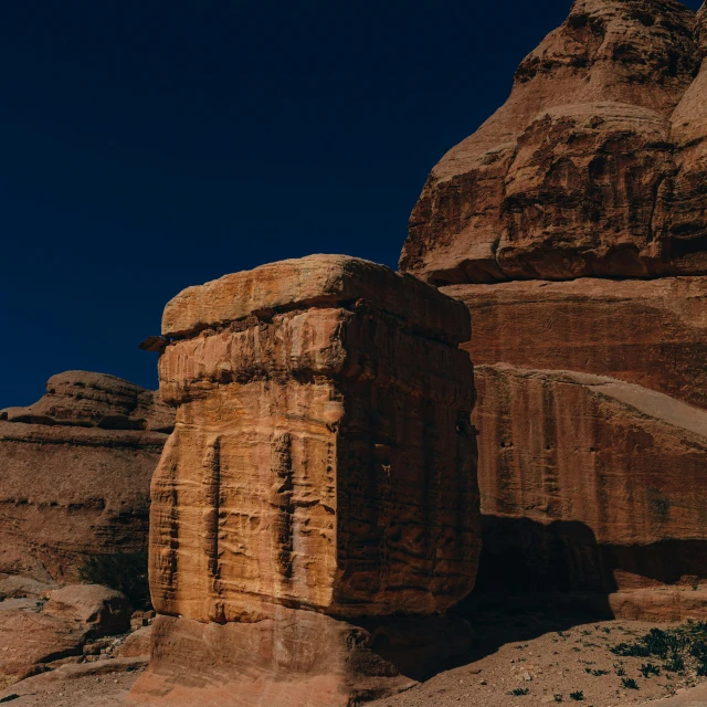 a large rock formation near a cliff on a sunny day